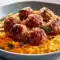 Close-up of golden-brown Apple And Sage Turkey Meatballs made with pork, garnished with crisp sage; a twist on Apple Sage Turkey Meatballs and bite-sized Apple Meatballs, served with roasted peppers for a nod to Ground Pork And Peppers Recipes.