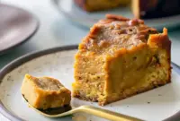 Close-up of a spiced pumpkin slice with a gooey center and caramel drizzle on a white plate.