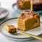 Close-up of a spiced pumpkin slice with a gooey center and caramel drizzle on a white plate.