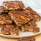 Salted Caramel Pretzel Bark — No Bake Holiday Recipes for Easy Entertaining Close-up of salted caramel pretzel bark: milk chocolate base layered with caramel ribbons and crunchy salted pretzels, broken into rustic pieces on parchment.