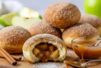 Caramel Apple Pie Bombs — Sweet & Gooey Dessert Apple Recipes Everyone Loves2 Close-up of caramel-filled apple pie bombs baked until golden brown, coated in cinnamon sugar and oozing warm caramel when pulled apart — bite-sized fall dessert made with biscuit dough and apple filling.