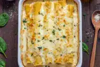 Close-up of golden baked Manicotti With Cheese Sticks inspired by a savory Chicken Manicotti Recipe, featuring a cheesy Stuffed Manicotti Recipe and perfectly tender Stuffed Manicotti fresh from the oven.