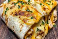 Cheesy garlic chicken wraps cooked until golden and melty, folded and sliced for a Quick Delicious Dinner, shown as an easy option for Chicken Wrap Recipes, Fast Dinner Recipes, and other Fun Easy Recipes.