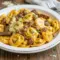 A one-pan creamy cheesesteak pasta skillet featuring Tortellini Recipes cooked Al Dente with sliced beef, peppers, and melted Provolone. A rich, cozy option for Pasta Dinners, Beef Dishes, Beef Casserole Recipes, and Pasta Dinner Recipes, perfect as an easy Main Dish Recipes idea with golden, cheesy tortellini close-up.