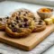 Close-up of chewy Pumpkin Brown Sugar Chocolate Chip Cookies with melted chocolate chips, showing their soft, golden texture — a cozy Pumpkin Butter Dessert Recipe perfect for fall.