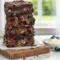 Rich, fudgy Greek yogurt brownies cut into squares on parchment paper—lightened-up Super Healthy Brownies made with Greek yogurt, minimal sugar, and chocolate chips, showing a dense, moist texture.