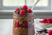 A jar of Dark Chocolate Overnight Oats topped with fresh raspberries and chocolate shavings, showcasing creamy Chocolate And Fruit Overnight Oats made with rich cocoa and oats, styled as Chocolate Raspberry Oats for an easy breakfast, inspired by How To Make Chocolate Raspberry Oats, perfect for Berry Chocolate Protein Overnight Oats, Chocolate Overnight Oats With Raspberries, Raspberry Chocolate Overnight Oats, Quick Chocolate Oats With Raspberries, and Raspberry Dark Chocolate Overnight Oats.