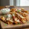Golden-brown hot honey BBQ chicken quesadillas sliced into wedges with melted cheese, served on a platter with dipping sauces for a party-style meal.
