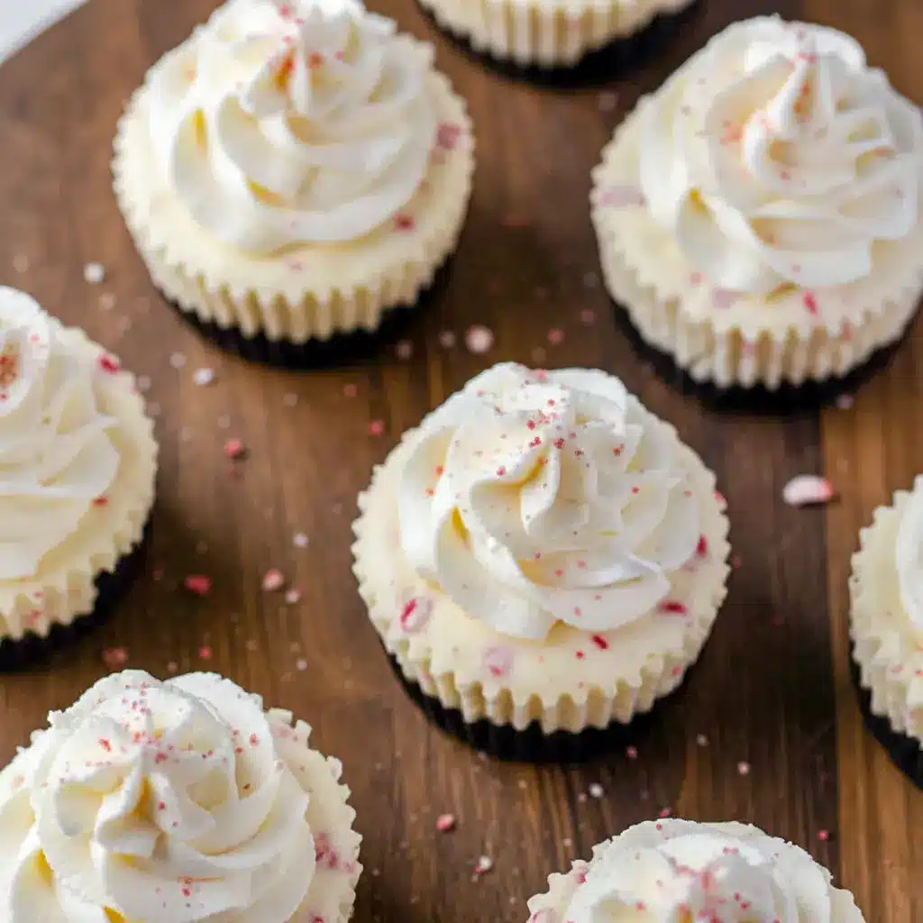 Mini no-bake peppermint cheesecakes with Oreo crust, whipped cream, and crushed peppermint candy sprinkled on top—festive holiday treats perfect for parties and Christmas gatherings.