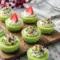 Bright green mini Grinch cheesecakes topped with whipped cream and sprinkles, displayed as fun Christmas bites perfect for parties, potlucks, and kid-friendly holiday treats.