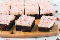 A batch of fudgy peppermint bark brownies topped with melted white chocolate and crushed candy canes, displayed as festive Christmas Desserts Bars perfect for holiday celebrations.