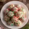 Festive Christmas Cheesecake Bites dipped in red and green chocolate, topped with sprinkles, and arranged on a holiday platter for an easy no-bake Christmas treat.