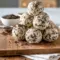 Creamy cookies-and-cream protein balls made with crushed Oreos and cream cheese, rolled into bite-sized snacks on a parchment-lined tray, perfect for no-bake meal prep and healthy snacking.