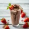 Chocolate strawberry protein smoothie in a glass topped with fresh strawberries, blending dessert-style flavor with a healthy, high-protein twist