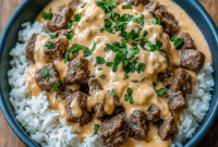A hearty bowl of Steak And Rice topped with juicy Steak Bites, fluffy rice, and creamy Cheese Sauce For Steak, perfect for an easy homemade Steak Dinner the whole family will love.