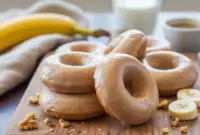 Freshly baked Banana Donuts Baked Healthy displayed on a cooling rack, showing golden edges and soft centers. These donuts double as Low Calorie Doughnut Recipes fans will adore and can easily be turned into Healthy Banana Donut Holes for snacking. Perfect for anyone searching for a Low Calorie Banana Muffin Recipe that feels indulgent without the guilt.