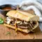 Golden steak sandwich on a baguette with melted Havarti and caramelized onions, perfect for Recipes To Last All Week and creative Cooked Sandwich Ideas, ideal for fans of Dinner Recipes With Sirloin Steak looking for truly satisfying Best Dinner Sandwiches.