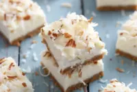 Creamy Coconut Cheesecake Bars topped with toasted coconut and almonds, a delicious Low Calorie Coconut Dessert perfect for healthy snacking or light dessert cravings.