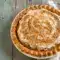 A slice of bourbon butterscotch pie topped with Butterscotch Whipped Cream and fluffy Molasses Whipped Cream, featuring a golden filling in a crisp Bourbon Pie Crust, styled as an elegant holiday dessert.