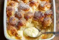 Warm snickerdoodle cobbler baked until golden in a casserole dish, showing a gooey cinnamon-sugar center and crisp edges, served fresh from the oven as a cozy fall dessert perfect for cool nights.