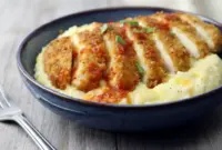 Chicken and Cheesy Grits served in a bowl with golden Cajun pan-fried chicken over creamy cheddar grits, finished with hot sauce, perfect for Dinner Recipes For Family Comfort Foods and cozy weeknight meals.