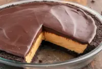Slice of Peanut Butter Pie With Chocolate Ganache featuring a creamy Skrewball peanut butter filling, Oreo crust, and a rich Peanut Butter Pie With Chocolate Ganache Topping perfect for fans of bold Peanut Butter Skrewball Recipes.