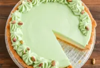 Slice of creamy Pistachio Pie Recipe topped with whipped cream and cherries in a Pie With Graham Cracker Crust, a fluffy Pistachio Cool Whip Dessert and classic Pistachio Pudding Cream Cheese Dessert perfect for any celebration.