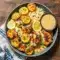 This Healthy Creamy Dinner features golden lemon butter chicken topped with creamy sauce, served alongside crispy mozzarella zucchini rounds and fluffy couscous for a vibrant One Dish Healthy Meal.