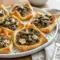 Fresh-from-the-oven Mushroom Puff Pastry Dish tarts layered with sautéed mushrooms, herbs, and creamy cheese, showcasing a golden Creamy Mushroom Puff Pastry filling inside crisp, flaky pastry squares.