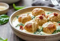 Creamy skillet of Chicken Ricotta Meatballs served with rich sauce, featuring Baked Chicken Ricotta Meatballs With Spinach Alfredo Sauce for a cozy dinner.