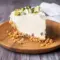 Slice of Italian Cannoli Cream Pie topped with whipped cream, pistachios, and mini chocolate chips, inspired by Italian Recipes Authentic Desserts and styled like a No Bake Cannoli Cream Pie with a crisp crust and creamy filling.