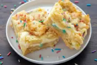 Stacked Sugar Cookie Cheesecake Bars with golden cookie crumble topping and creamy cheesecake center, festive Keto Sugar Cookie Cheesecake Bars ideal for Keto Birthday Dessert tables and fans of Keto Cream Cheese Bars.