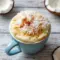 Vanilla Coconut Cottage Cheese Mug Cake served warm in a white mug, topped with toasted coconut, showcasing a soft and fluffy Coconut Cottage Cheese Mug Cake perfect as a Sweet Cottage Cheese Snack.