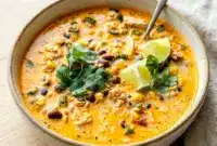 Creamy Chicken, Poblano, and Black Bean Soup served with cilantro and lime in a rustic bowl, inspired by Southwest Chicken Poblano Soup and cozy Poblano Pepper Recipes Soup ideas.