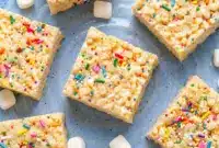 Soft and gooey Protein Rice Krispies stacked on a plate with melted marshmallows and colorful sprinkles, perfect for easy Low Calorie Protein Rice Crispy Treats and homemade Rice Krispie Protein Bar ideas.
