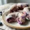 Freshly glazed Blueberry Cake Donuts stacked on a cooling rack with juicy blueberries, perfect for a High Protein Donut Recipe and healthy breakfast treat.