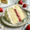 Beautiful layered Vanilla Cake With Strawberry Filling And Cream Cheese Frosting topped with creamy swirls and fresh strawberry filling, inspired by a rich Moist Vanilla Cake With Strawberry Filling and classic White Cake Strawberry Filling desserts.