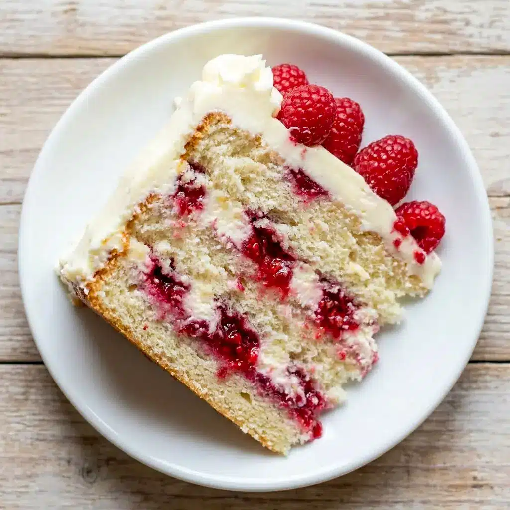 Beautiful White Chocolate Raspberry Dream Cake topped with raspberries and creamy frosting, a stunning Best Layered Cake and elegant choice for Birthdays Desserts and Cakes With Raspberry Filling lovers.