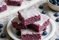 Moist and chewy Blueberry Brownies topped with a sweet vanilla glaze, an easy Blueberry Brownie Recipe and one of the best Easy Desserts With Blueberries for summer gatherings.
