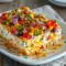 Cowboy Caviar Jalapeno Popper Cheese Log served as a colorful Appetizer To Bring To A Party, topped with fresh cilantro and crunchy tortilla chips.