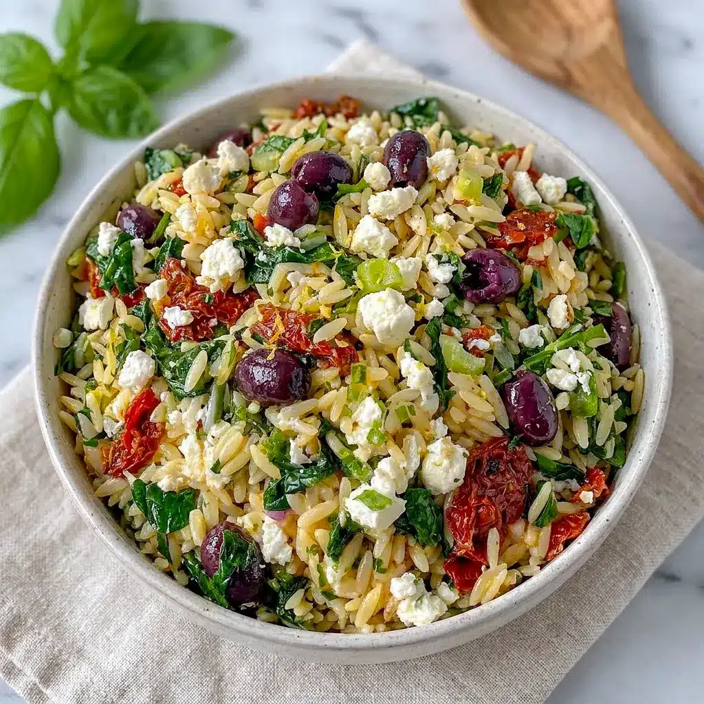 A bright bowl of Sundried Tomato Feta Orzo Salad with herbs and olives, perfect for Mediterranean Orzo Pasta Salad Recipes that taste fresh and satisfying.