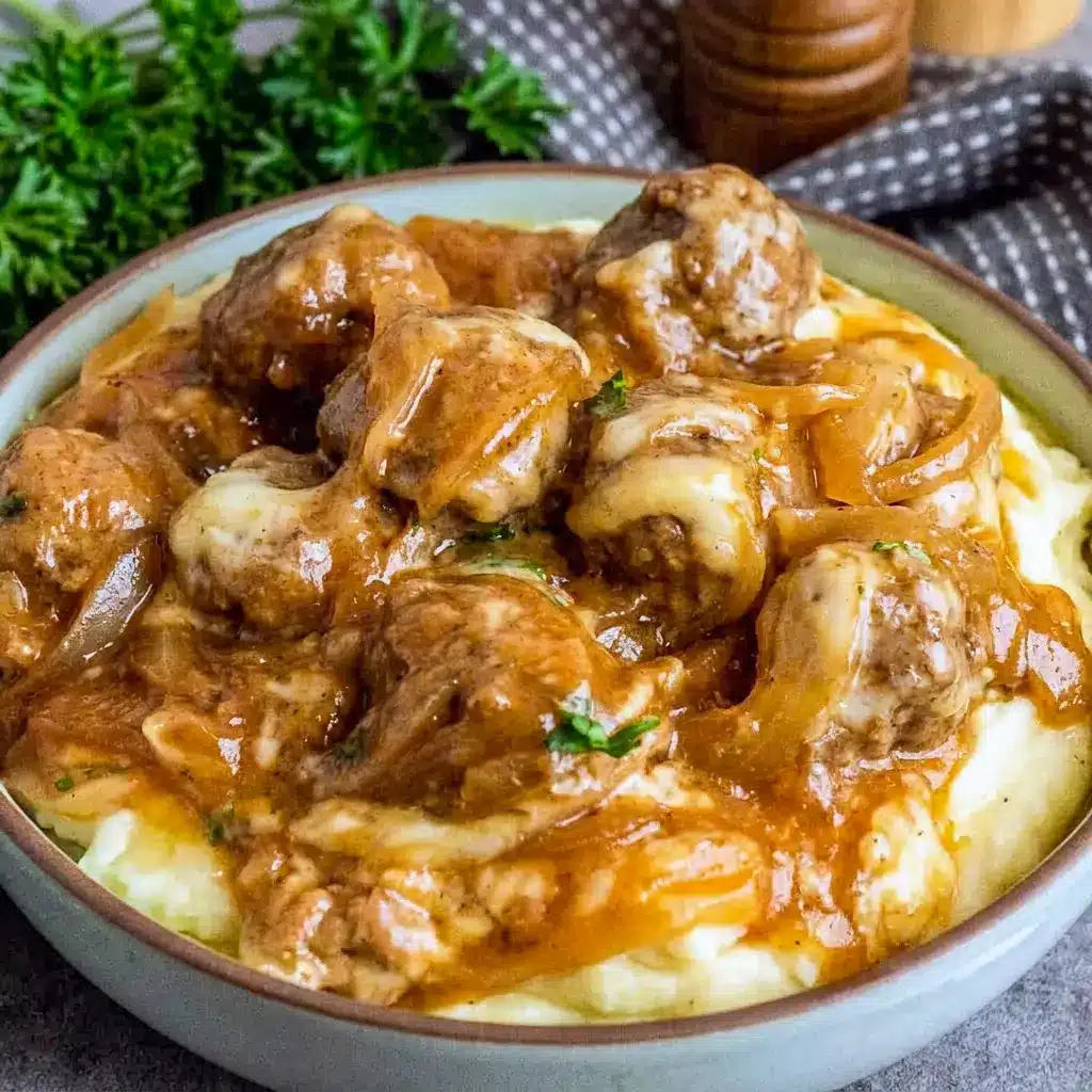 Crock Pot French Onion Meatballs served over creamy mashed potatoes with plenty of cheesy onion sauce, perfect for Dinner Recipes Crockpot inspiration.